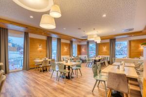 巴德小基希海姆COOEE alpin Hotel Bad Kleinkirchheim的餐厅设有桌椅和窗户。