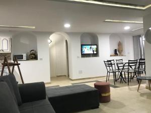 阿格希尔Dar Slima的客厅配有沙发和墙上的电视