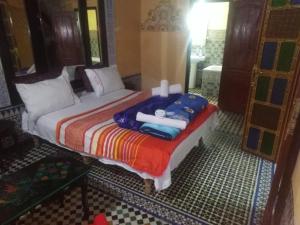 非斯riad zahra的一间卧室配有带毛巾的床