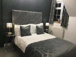 瓦伊河畔海伊The Smithy的一间卧室配有一张带灰色床头板的床和两盏灯。