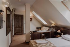 Kwilcz欧兰迪亚酒店的一间卧室配有一张床、一张书桌和一个窗户。