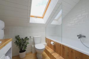 巴拉顿菲赖德Lotti Residnece Familyar的浴室配有白色卫生间和天窗。