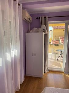 贝西奇Rooms Florie的紫色的客房配有白色橱柜和桌子
