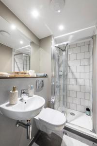 坎特伯雷Studios and Ensuite Bedrooms with Shared Kitchen at Riverside in Canterbury的白色的浴室设有水槽和淋浴。