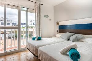 科拉雷侯Villa Paraíso的一间卧室设有两张床和大窗户