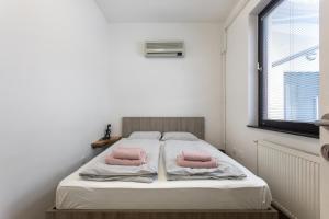 卢布尔雅那BIG PIPE apartment的一间卧室配有一张带两个粉红色枕头的床