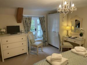 邓斯特Millstream Cottage B & B的一间卧室配有书桌、一张床和一个梳妆台