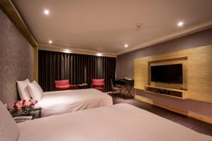 台南夏都富朗酒店的酒店客房设有两张床和一台平面电视。