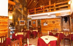 佩休尼亚镇帕拉伊索宾馆的用餐室设有桌椅和木墙