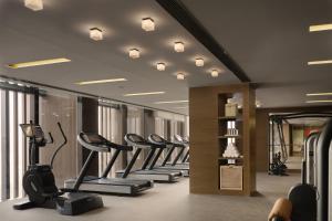 北京北京瑰丽酒店的健身房,带有一排跑步机和椭圆机