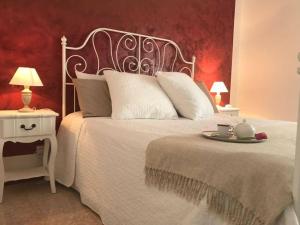 奥斯图尼Residenza Aurora的卧室配有白色的床,并备有托盘