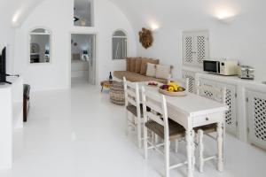 伊亚Ambi Villas Santorini的白色的客厅,配有一张桌子和一碗水果