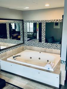 科尔宾Super 8 by Wyndham Corbin KY的浴室内设有一个带两面镜子的大浴缸