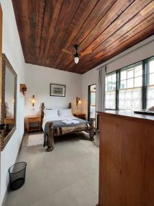 蒂拉登特斯Cama e Café Tiradentes的一间卧室设有一张木天花板床。