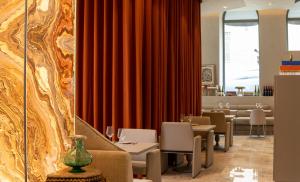 里斯本Dos Reis by The Beautique Hotels的餐厅设有红色窗帘和桌椅