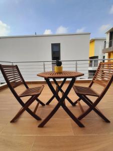阿克拉Beautiful Home - 2 Double Rooms的阳台上配有一张木桌和两把椅子