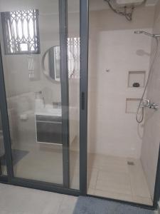 阿克拉Beautiful Home - 2 Double Rooms的浴室内带水槽的玻璃淋浴间门