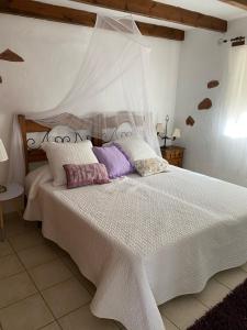 TetirCasa Maida的卧室配有带枕头的大型白色床