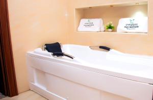 阿布贾Modern Luxury Home W/ 24H Power Wi-Fi & Security的浴室设有白色浴缸及镜子