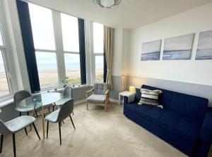 锡斯凯尔6 Burnett by Prestige Properties SA的客厅配有蓝色的沙发和玻璃桌
