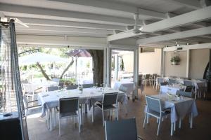 蒙塔尔托迪卡斯特罗HOTEL VULCI的一间设有白色桌椅的用餐室