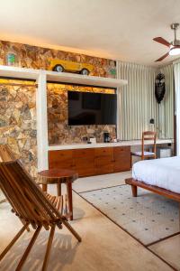 ConkalLa Parcela Cunkal的一间卧室设有一张床,石墙上配有电视。