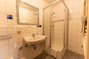 MettendorfHotel Fronhof Mettendorf的白色的浴室设有水槽和淋浴。