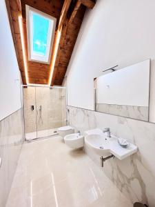 阿杰罗拉La Villa Carmelina的一间带两个盥洗盆、卫生间和窗户的浴室