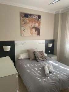 桑卢卡尔-德巴拉梅达Apartamento Acogedor的一间卧室配有一张带书桌和绘画的床。