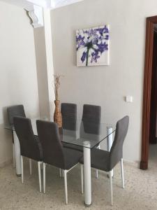 桑卢卡尔-德巴拉梅达Apartamento Acogedor的餐桌、椅子和花瓶