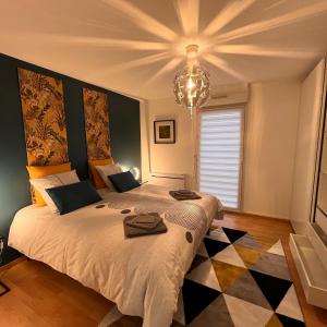 奥尔良Maison COMet avec jardin et parking的一间卧室配有一张大床和一个吊灯。