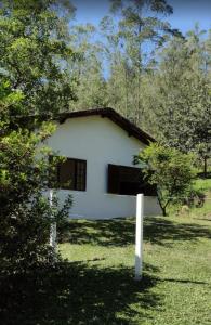 圣路易斯-杜帕赖廷加Casa de Campo no Parque Estadual da Serra do Mar的田野中间的白色房子