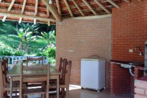 圣路易斯-杜帕赖廷加Casa de Campo no Parque Estadual da Serra do Mar的桌子、椅子和冰箱
