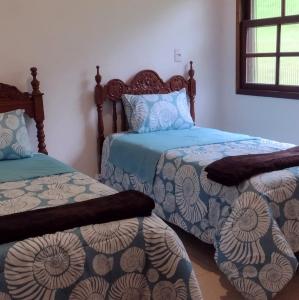 圣路易斯-杜帕赖廷加Casa de Campo no Parque Estadual da Serra do Mar的一间卧室设有两张单人床和一个窗户。