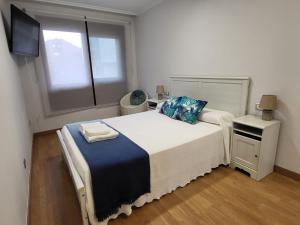 博伊罗Playa Jardin Boiro的卧室配有一张大白色床和窗户