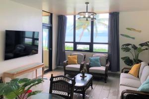 乌马考Beachfront Getaway for two!的客厅配有沙发、椅子和电视