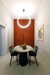 维罗纳Casa Caleido的用餐室配有桌椅和灯