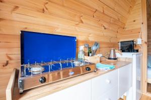 WarmondTiny Camping Pod的厨房配有大屏幕平面电视,设有木墙