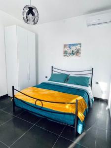 塔尔奎尼亚CASA DANI的一间卧室配有一张黄色和蓝色毯子的床