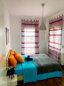 普里诺斯VILLA ARMONIA GUEST HOUSE的一间卧室配有带橙色枕头的床和窗户。