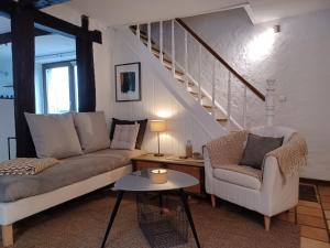 博兰Maison d'Engon charme nature的带沙发和椅子的客厅以及楼梯。