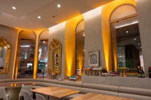 里斯本Dos Reis by The Beautique Hotels的餐厅拥有黄色的墙壁、桌子和镜子