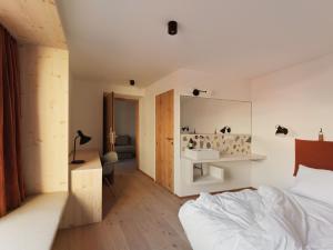 因斯布鲁克Urban Inn - Wilten 24/7的一间卧室配有一张床、一张书桌和一面镜子