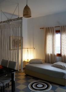 米尔泰Panorama Studios & Apartments的卧室配有一张床、一张书桌和窗户。