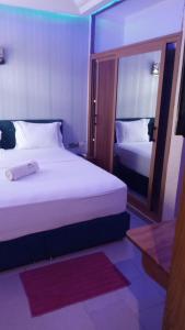 科托努HÔTEL NOAHGARDEN 2的酒店客房,设有两张床和镜子