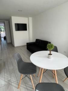 波哥大Hermoso apartamento moderno, excelente ubicación cerca al centro histórico的客厅配有白色的桌子和椅子