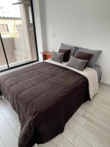 波哥大Hermoso apartamento moderno, excelente ubicación cerca al centro histórico的卧室设有一张大床,卧室设有大窗户