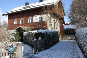 伦格里斯Gästehaus Werner的雪中带围栏的房子