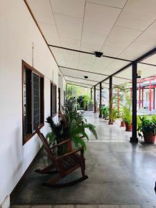 利比里亚Hotel Del Aserradero的大楼内带长凳和植物的走廊
