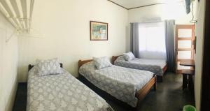 利比里亚Hotel Del Aserradero的客房设有两张床、梯子和窗户。